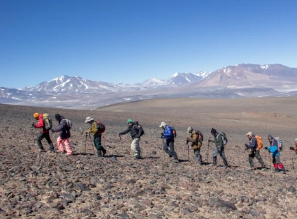 Grupo de montañeros caminando hacia el monte Ojos del Salado.